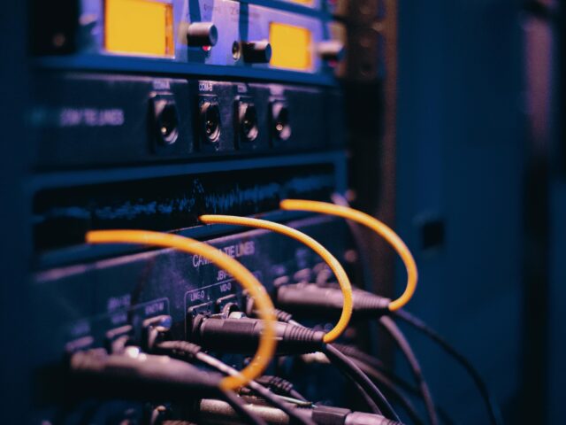 pexels-photo-1054397-1054397 Close-up of network cables and ports in a server rack, showcasing connectivity.