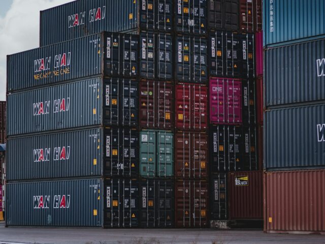 pexels-photo-3735930-3735930-1 High vertical stack of cargo containers at a port, symbolizing global logistics.